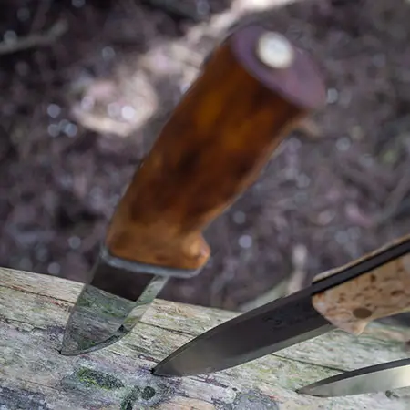 3 bushcraft knives sticking in a log and link to our bushcraft knives collection page