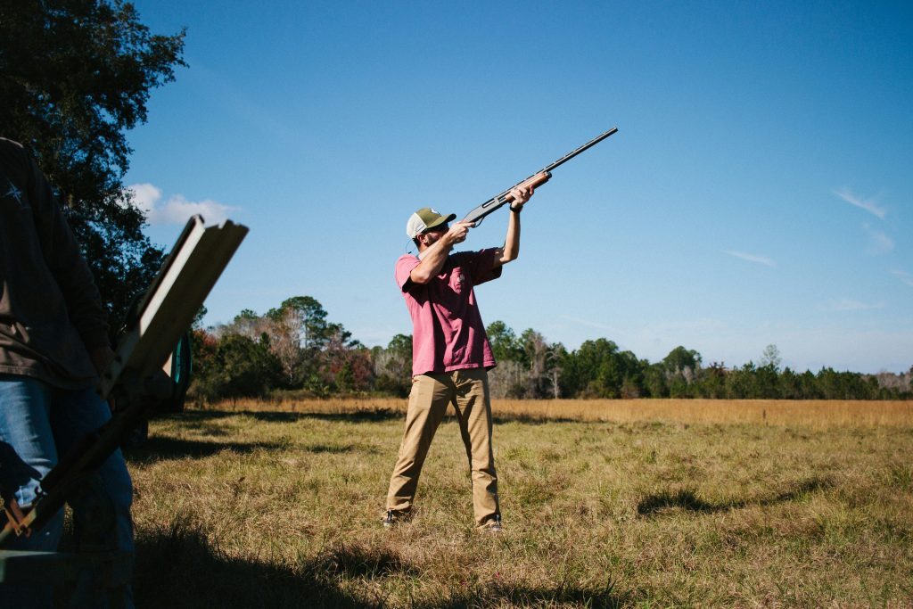 A man aiming an air rifle up towards the sky