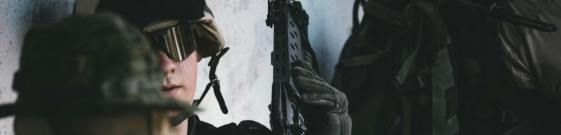 Airsoft player hiding by wall