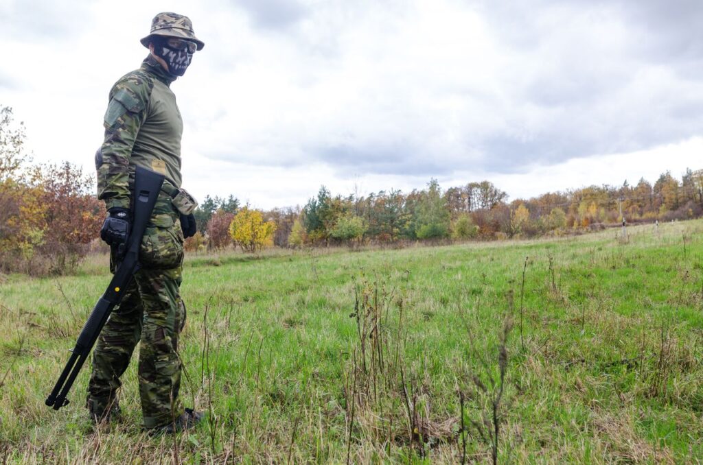 Airsoft player wearing protective camo trousers