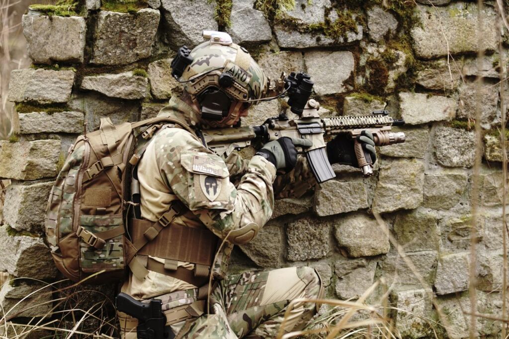 Airsoft player by brick wall