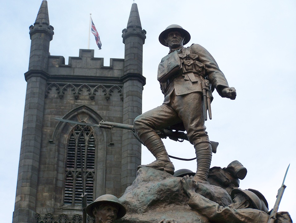 A war memorial featuring a soldier by a church in the UK