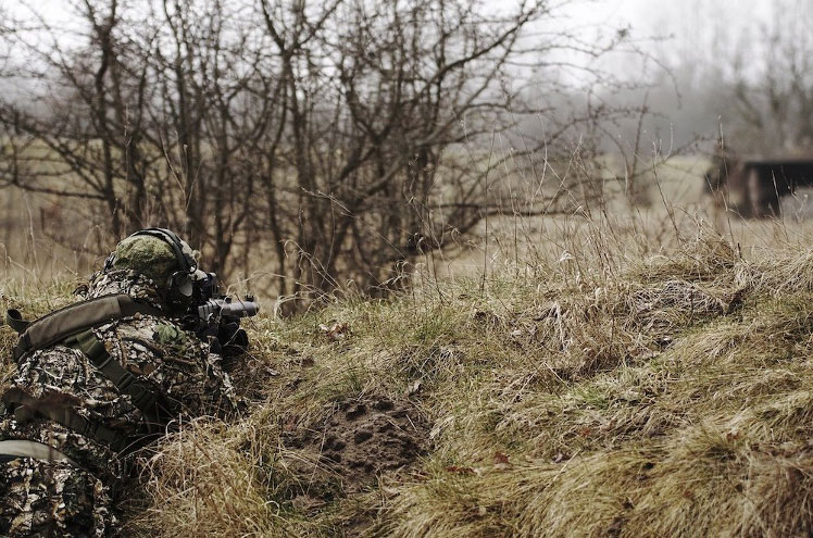 A man playing airsoft outdoors