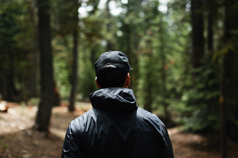 A man in the woods wearing a raincoat