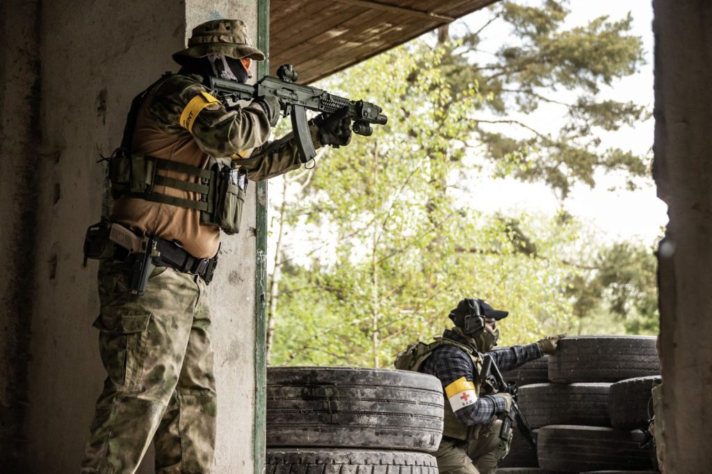 Two airsoft players hiding behind cover