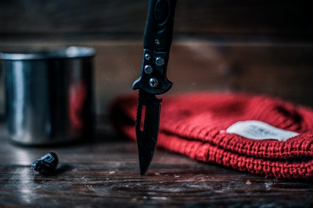 A knife stuck into a wooden table