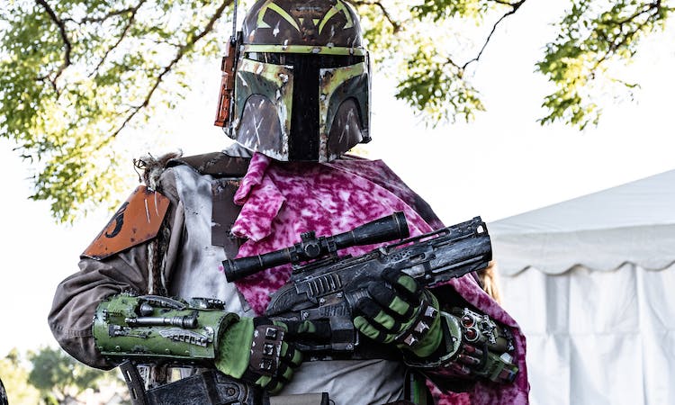A cosplayer in a Stars Wars costume with a painted gun
