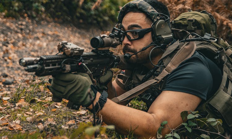 An airsoft player with a gun with various attachments