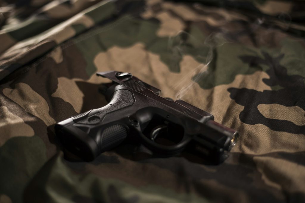 An airsoft pistol on camo fabric
