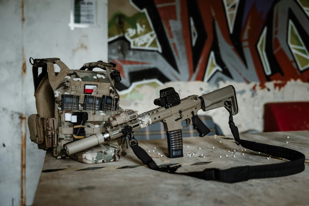 An airsoft player lying on the ground aiming a gun
