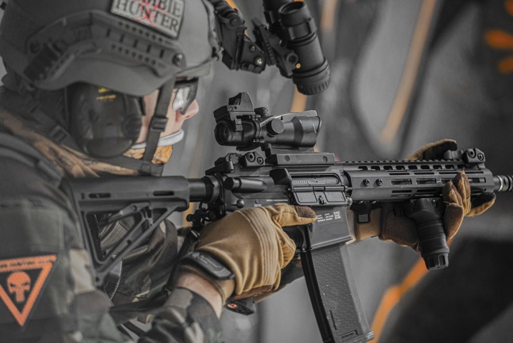 An airsoft player in military fatigues with an airsoft rifle