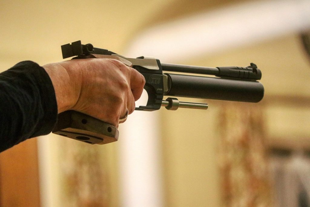 A hand holding an air pistol in a firing stance