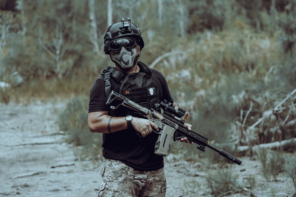Man with airsoft gun wearing helmet and mask