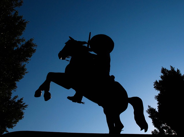 Cowboy rides off into the night with rifle. 