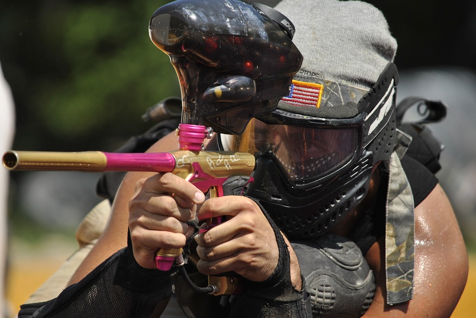 A person firing a paintball gun. 