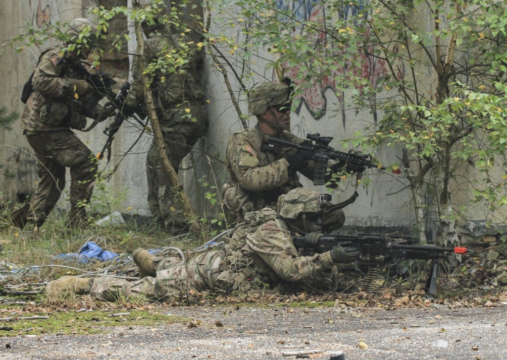 Support gunner laying down with team in background