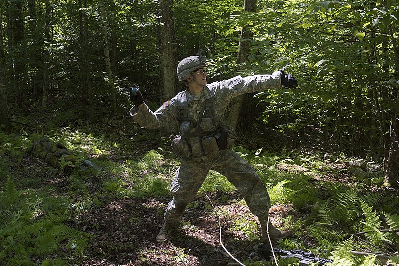 A man preparing to throw a grenade