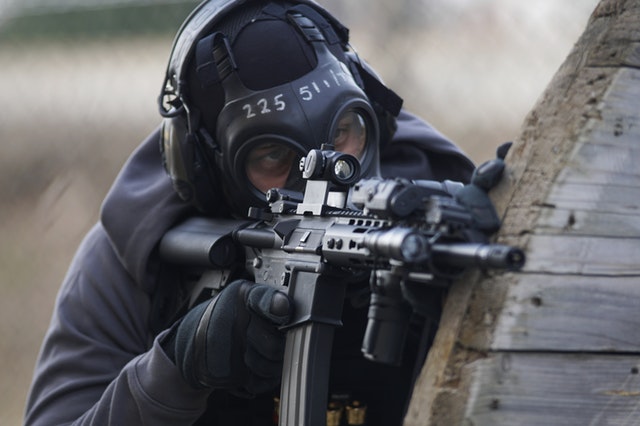 Man aiming airsoft rifle from behind cover