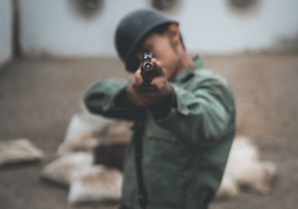 A man aiming a gun with open sights