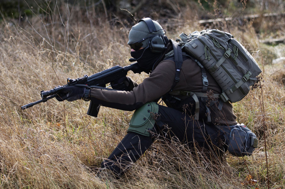 Airsoft player crouched with airsoft rilfe