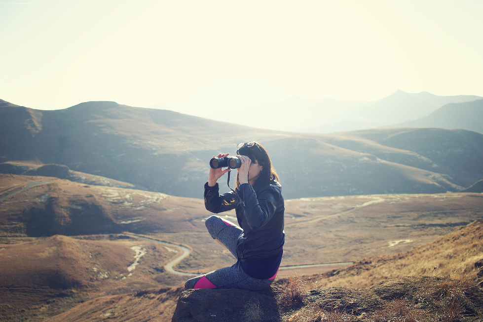 Person crouching with binoculars