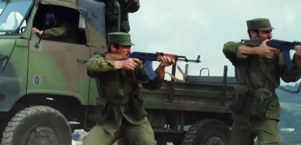 Two men holding AKM rifles