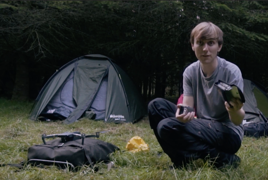 Man crouched down by tent