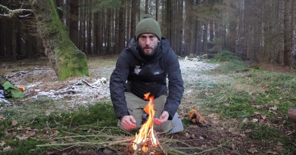 Man kneeling down by a fire